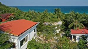A coastal property with a red-roofed building, lush greenery, and a view of the ocean. - Sunrise Vuth Resort (Koh Rong)