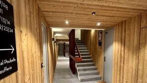 Un passadís interior de fusta amb una escala que mena a una altra habitació.