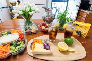 A wooden table with food items, a pitcher, a glass of iced tea, and a box of crispbread.