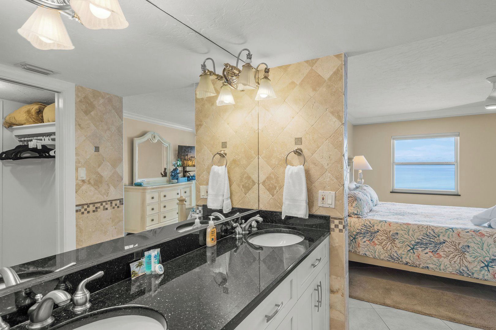 A hotel bathroom with a double sink, vanity, and a large mirror.