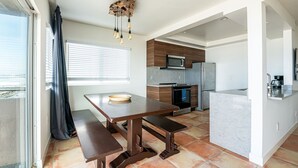 Une cuisine moderne dotée d’un îlot central, d’appareils électroménagers intégrés et d’un coin repas avec des bancs.