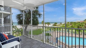 Un balcon avec vue sur une piscine et une plage.