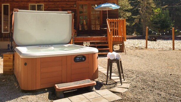A wooden cabin with a hot tub, a deck, and a covered seating area. - Excepional spacious lodge 5 min frm Roslyn slps 12, huge loft, WIFI, Hot Tub,  (Ronald)