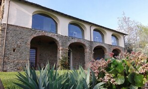A building with a stone facade, multiple arched windows, and a flat roof. - Antico Convento (Garessio)