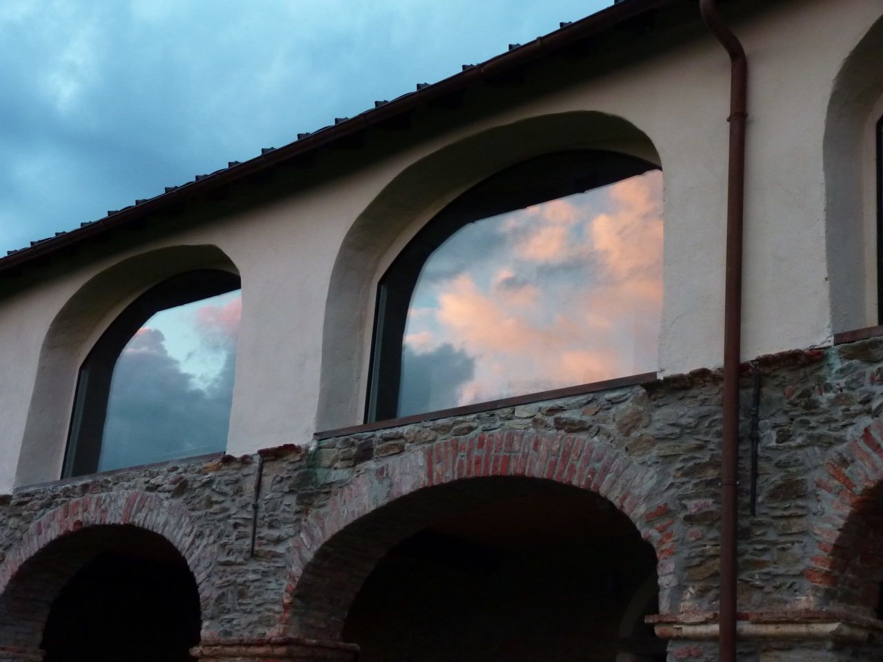 Un puente de piedra con múltiples arcos y un cielo despejado con nubes.