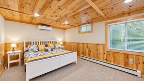 A bedroom with a bed, bedside tables, an air conditioning unit, a window with blinds, and a radiator. - Grand Jay Lodge, Ultimate Log Luxury, Stunning Views, Hot Tub & Sauna, EV Charger, 3D Tour (Jay)