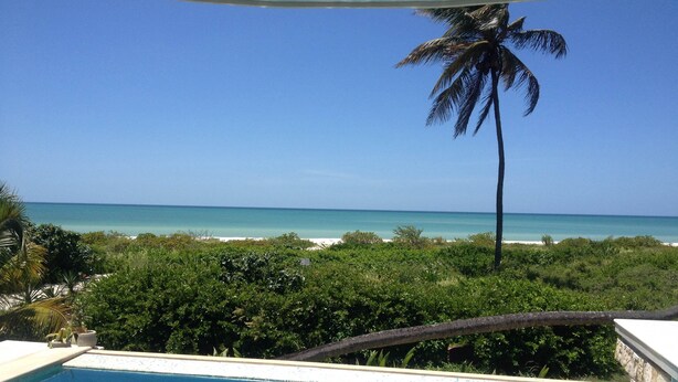 Vista clara de uma piscina com vista para a praia e o oceano.