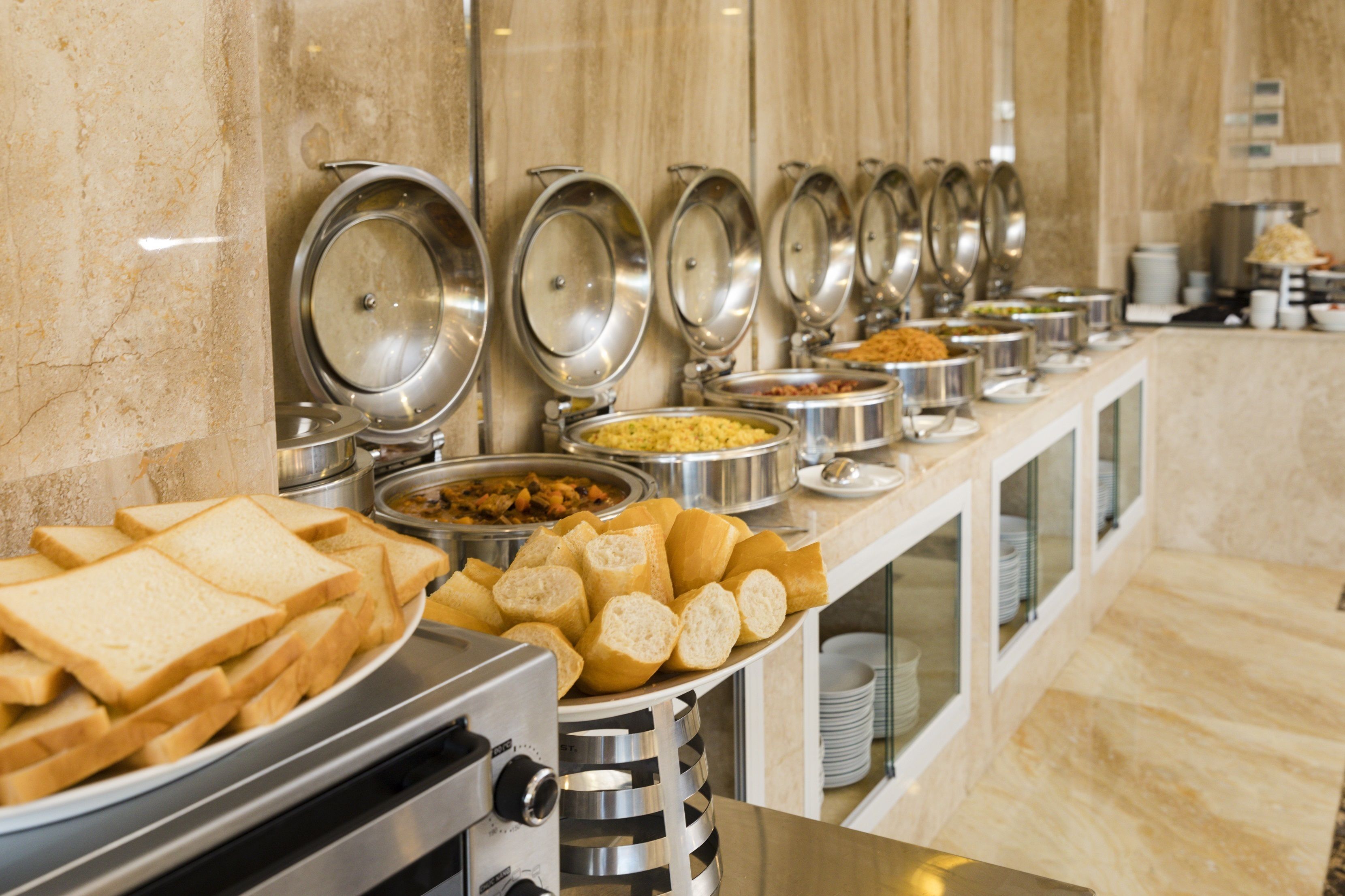 A buffet with various food items and bread.