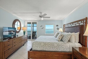 A bedroom with a bed, a TV on a dresser, a ceiling fan, and a view of the ocean. - Crystal Sands Tower Unit 704 - Beachfront (Sarasota)