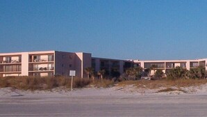 A coastal hotel with multiple floors, balconies, and a sandy beach in the background. - SEASIDE ESCAPE ON ST. AUGUSTINE BEACH - WHERE OLD IS NEW AGAIN!!! (St Augustine Beach)