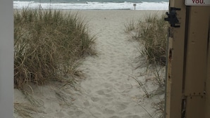 A beach entrance with a sign instructing to close the gate behind you.
