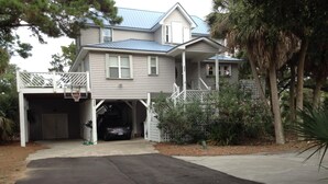 A two-story house with a garage, a covered driveway, and a small porch.