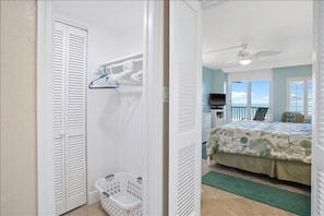 A bedroom with a bed, a ceiling fan, a TV, and a view of the ocean. - Crystal Sands Tower Unit 710 - Beachfront (Sarasota)