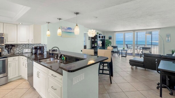 A spacious kitchen with a large island, modern appliances, and pendant lighting. - Crystal Sands Tower Unit 805 - Beachfront (Sarasota)
