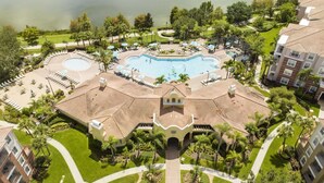 A resort with a central swimming pool, multiple lounge areas, and a well-maintained garden. - Vista Cay Resort Townhome near Convention/Universal/SeaWorld/Single Greek Golf (Orlando)