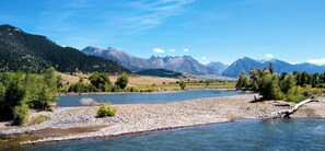 Une rivière aux rives rocheuses, avec une chaîne de montagnes en arrière-plan.