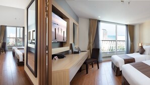 A hotel room with two beds, a desk, a TV, and a balcony with a view. - Sao Viet Hotel (Nha Trang)
