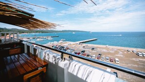 A balcony with a view of a beach, a pier, and boats. - Navarro Hotel (Malay)