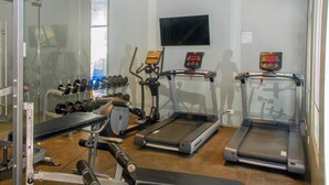 Ein Fitnessstudio mit Laufbändern, Hanteln und Kraftgeräten.