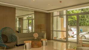 Eine moderne Lobby mit einer Couch, einem runden Couchtisch und einem Hängekorbstuhl.
