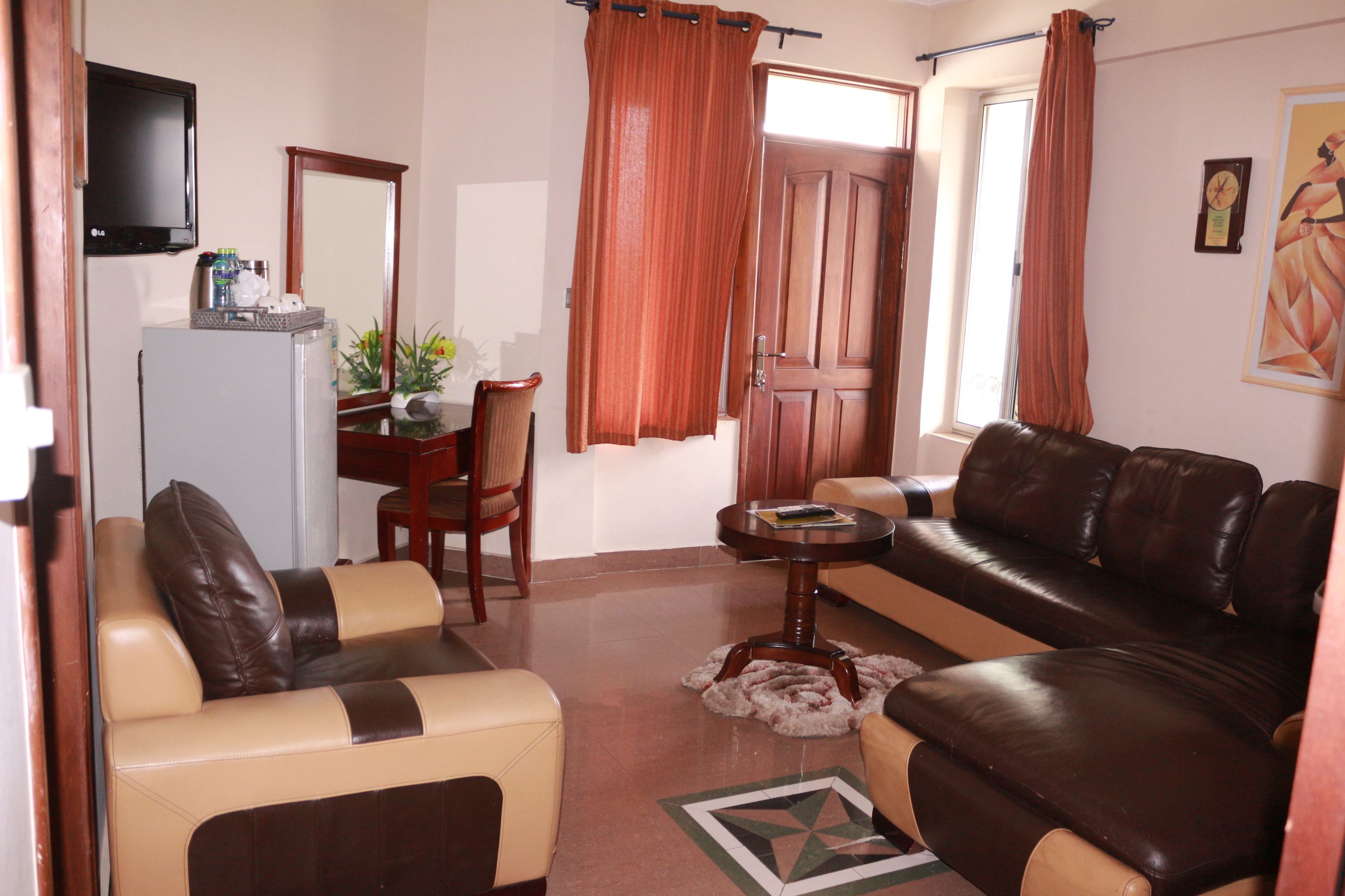 Una sala de estar con un sofá, una mesa de centro, un televisor y un comedor con una silla y una mesa.