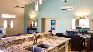 Une cuisine dotée d’un plan de travail en granit, d’un évier et d’un ventilateur de plafond.