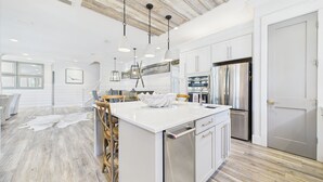 A modern kitchen with white cabinetry, stainless steel appliances, and a central island. - 4 Bedroom Grayton Luxury-Elevator-Sleeps 12- Private beach access with set-up (Santa Rosa Beach)