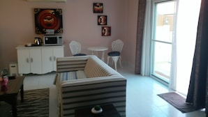 A living room with a sofa, chairs, a small table, and artwork on the wall. - Studio Deluxe Avec Services Hôteliers - Adults Only (Rawai)