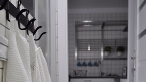Uma cozinha com armários brancos, painel de azulejos e fogão.