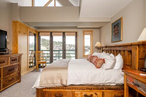 Relax in a spacious bedroom with a large bed, wooden dresser, and comfortable chair.