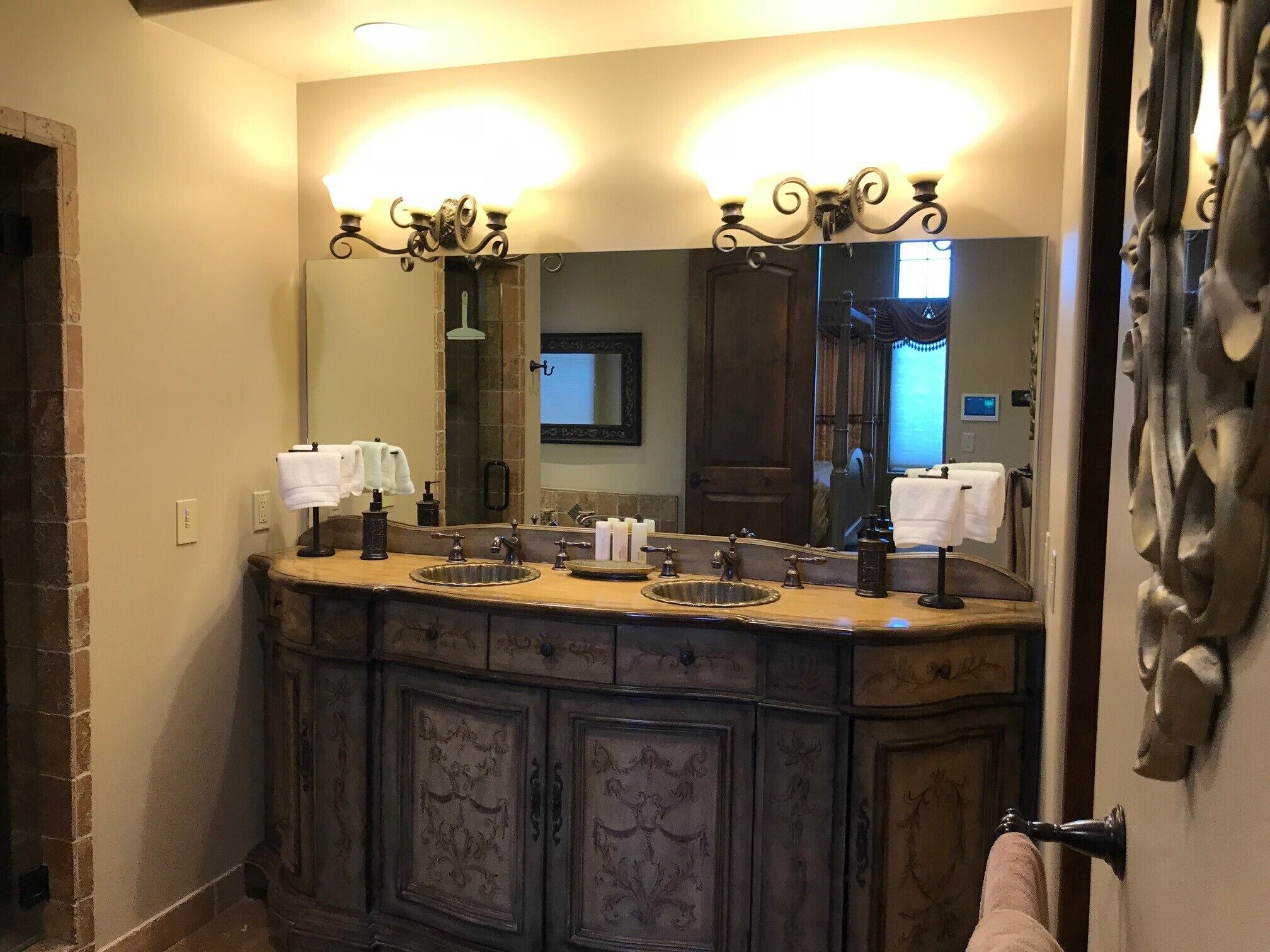 A bathroom with a large mirror, two sinks, and a towel rack.