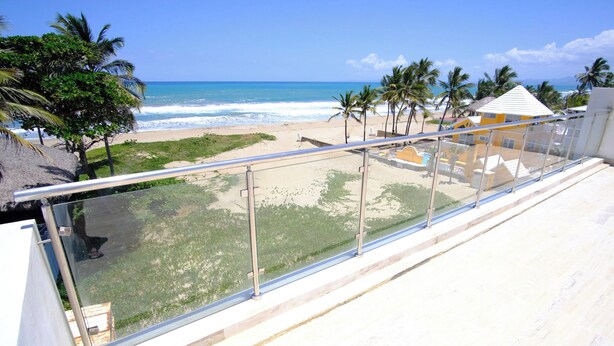 A balcony with a view of a beach and ocean. - Great Oceanfront Condo with Private Pool on Beach (Cabarete)