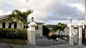 Une propriétéClose, avec un bâtiment blanc, un palmier et un ciel dégagé.