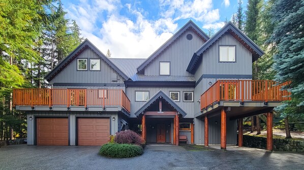 A two-story house with a garage, a covered porch, and a balcony.