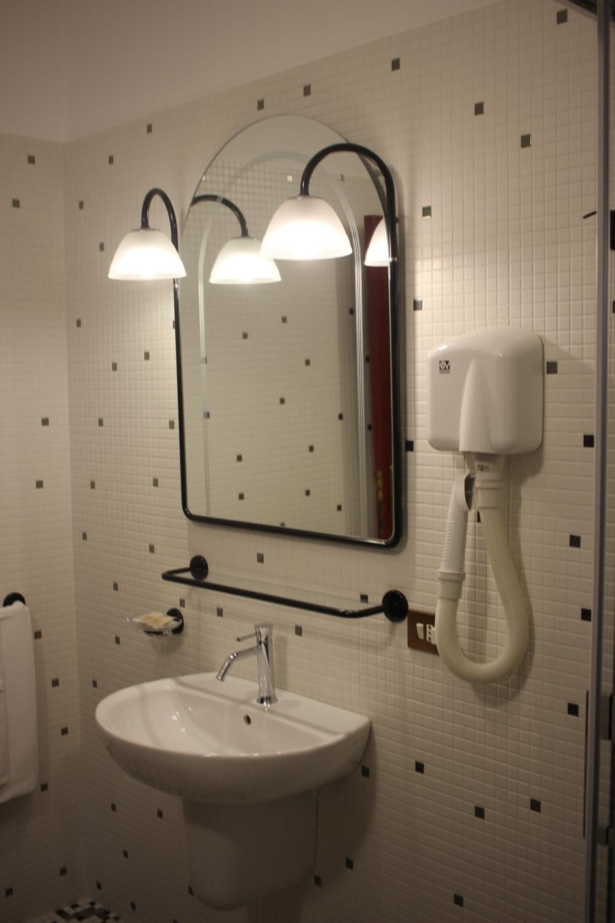 A bathroom with a white sink, a mirror, and two wall-mounted lights.