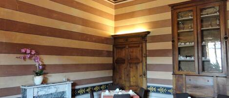 A dining area with striped walls, wooden cabinets, and tables set for dining.