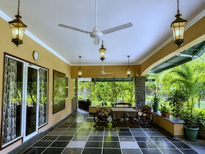A covered patio area with a ceiling fan, hanging lanterns, a table with chairs, and potted plants. - Park Exotica Resort & Spa - Near Fateh Sagar Lake, Udaipur (Udaipur)