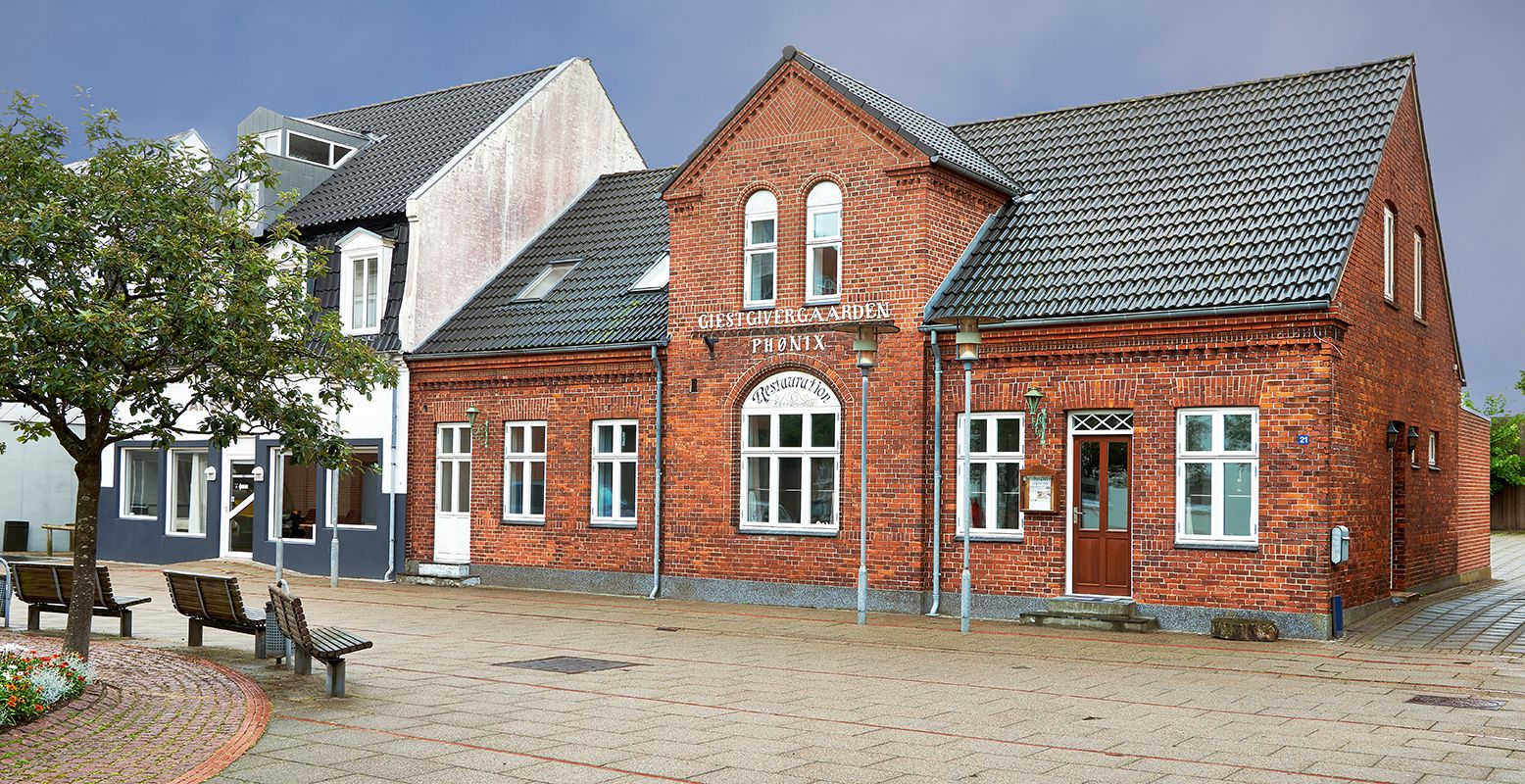 A brick building with a sign reading "Gjestive Garden Photoix."