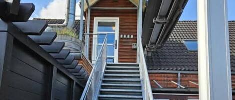 A staircase leading to a bed and breakfast named 'PHONIX' with a wooden exterior and a metal railing.