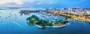 An aerial view of a marina with boats, a bridge, and a cityscape with buildings. - Crystal Sands Villa 13 - Private Beach (Sarasota)