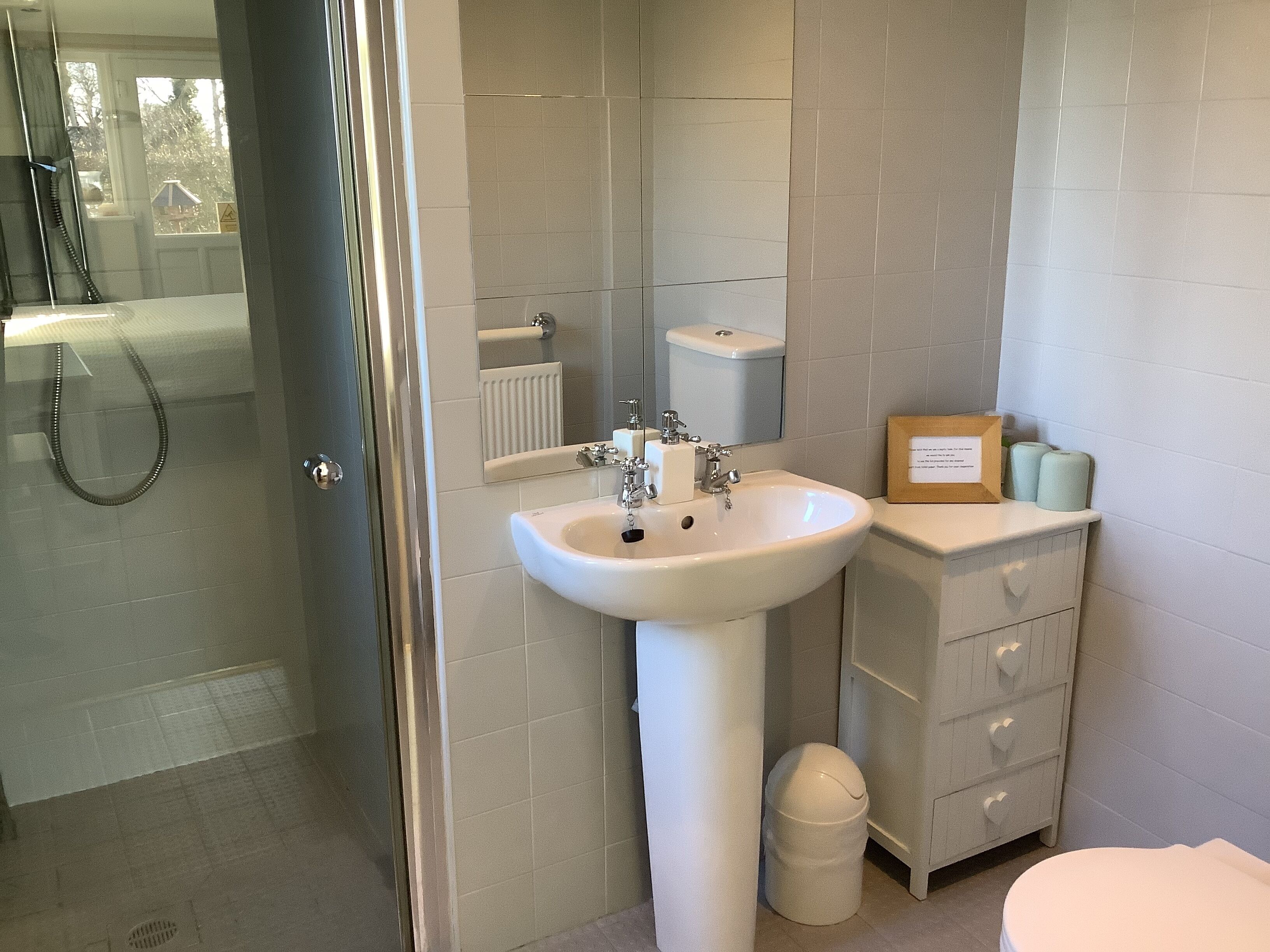 Un bagno con lavandino, WC e doccia.