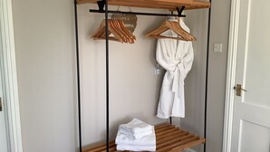 A wooden drying rack with towels and a robe hanging on it. - Villa Farm Cottage (Ulceby)