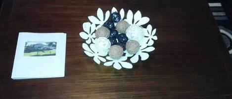 A wooden table with a decorative plate of spherical objects and a photograph.