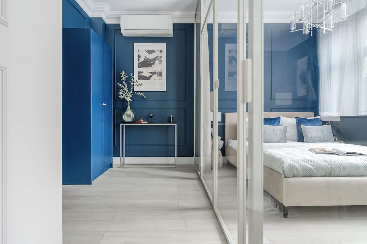 A modern bedroom with a bed, bedside table, and a vase with flowers.