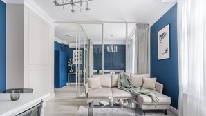 A modern living room with a sofa, coffee table, and a glass partition.