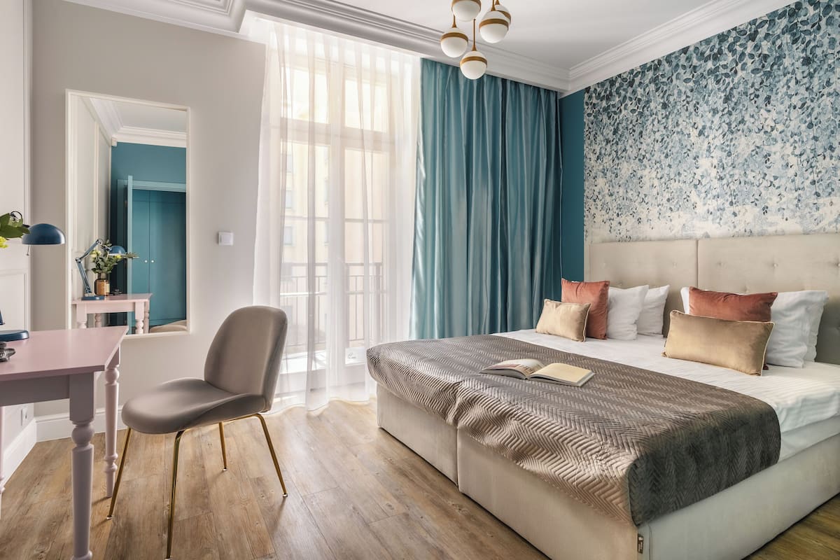 A bedroom with a large bed, a desk, and a chair.