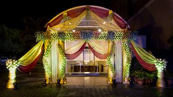 Una entrada decorada con telas drapeadas y arreglos florales.