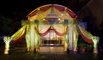 Una entrada decorada con telas drapeadas y arreglos florales.