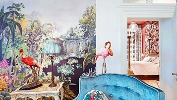 Une chambre décorée d’une fresque représentant la faune tropicale et dotée d’un lit orné d’un flamant rose.