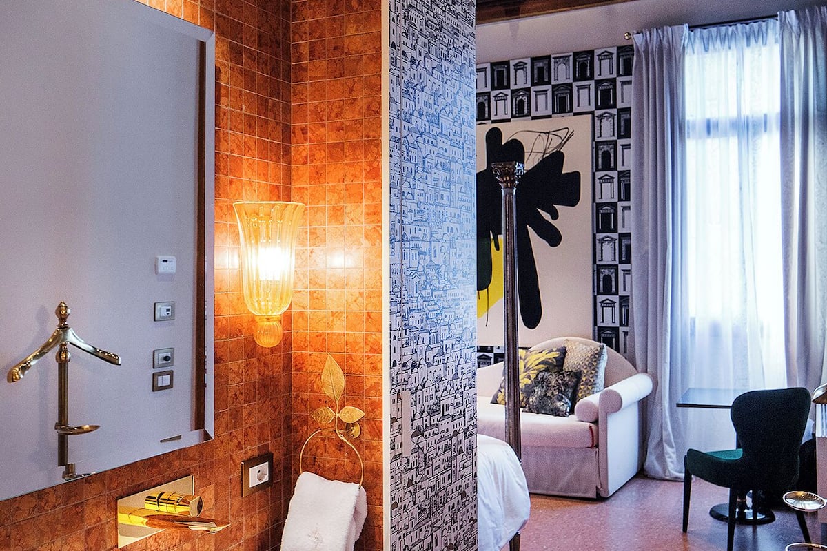 A modern bathroom with a large mirror, a sink, and a towel rack.
